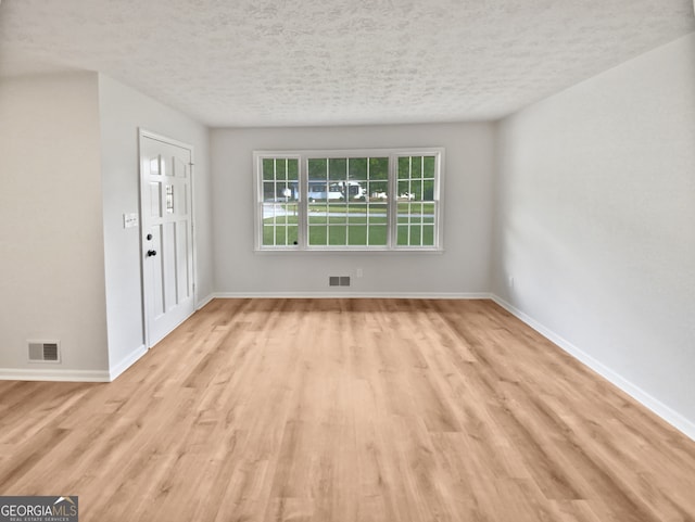 interior space featuring a textured ceiling and light hardwood / wood-style flooring