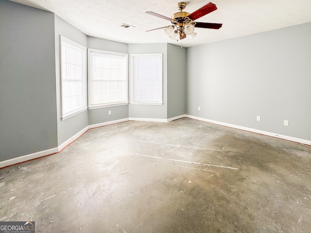 unfurnished room featuring ceiling fan, concrete floors, and a textured ceiling