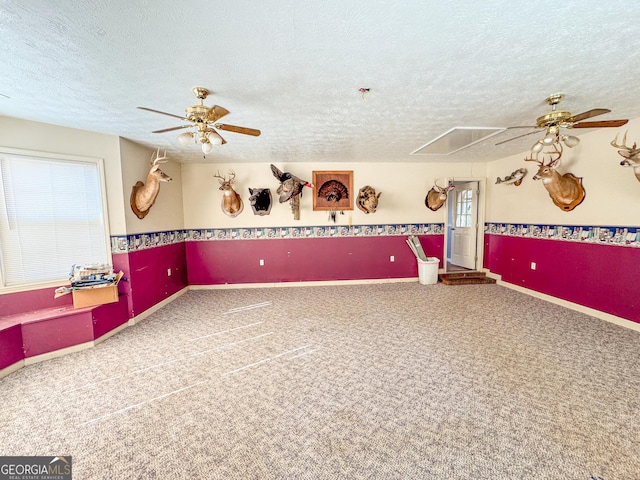 empty room with a textured ceiling, ceiling fan, and carpet flooring