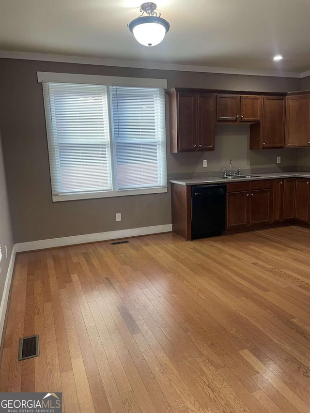 kitchen featuring crown molding, dishwasher, light hardwood / wood-style flooring, and sink