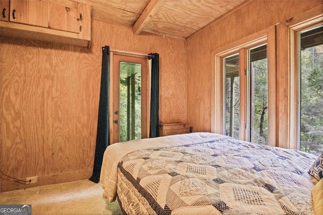 bedroom with carpet, wood walls, wooden ceiling, and access to outside