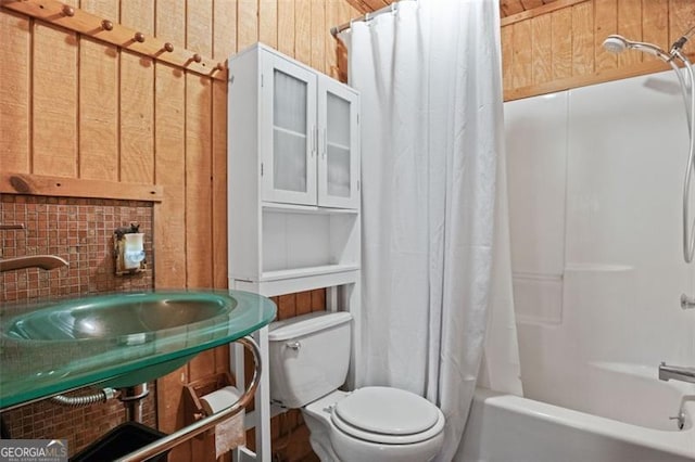 full bathroom featuring shower / tub combo with curtain, wood walls, sink, and toilet