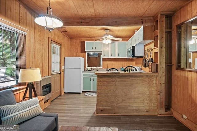 kitchen with wooden walls, white refrigerator, plenty of natural light, and light wood-type flooring