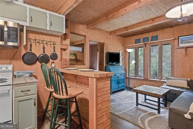 kitchen with beamed ceiling, wooden walls, dark hardwood / wood-style floors, and white range