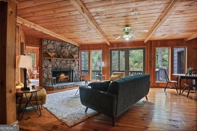 living room with wood-type flooring, wood walls, and plenty of natural light