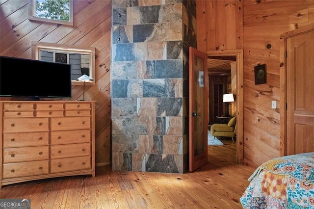 bedroom featuring wood walls and hardwood / wood-style floors