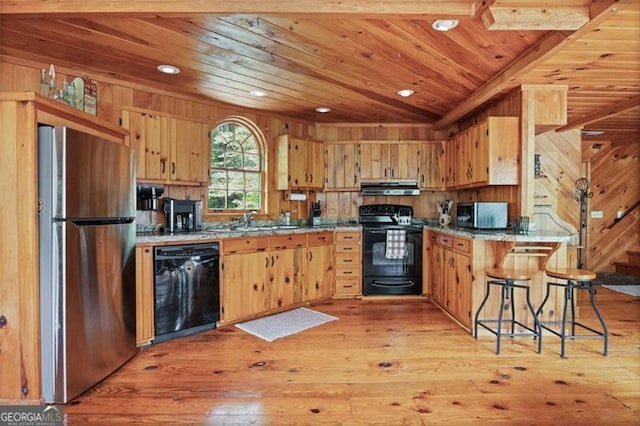 kitchen featuring light wood-type flooring, a kitchen breakfast bar, black appliances, extractor fan, and wooden ceiling