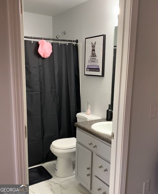 bathroom with a shower with shower curtain, vanity, and toilet