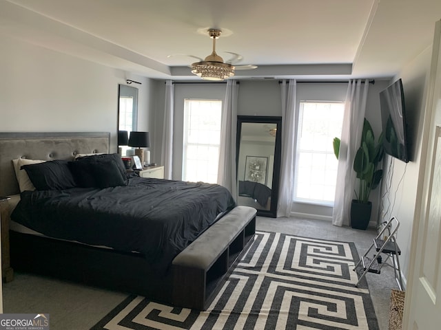 carpeted bedroom with multiple windows and ceiling fan