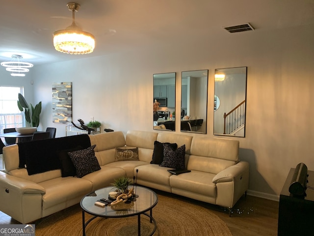 living room with wood-type flooring and an inviting chandelier