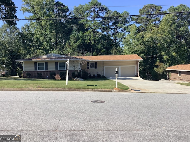 view of front of home featuring brick siding, an attached garage, driveway, and a front lawn