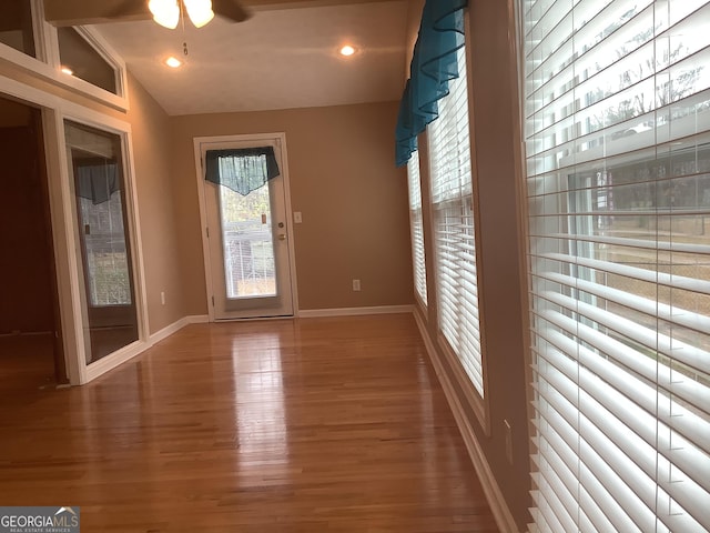 doorway with wood finished floors, baseboards, lofted ceiling, recessed lighting, and ceiling fan