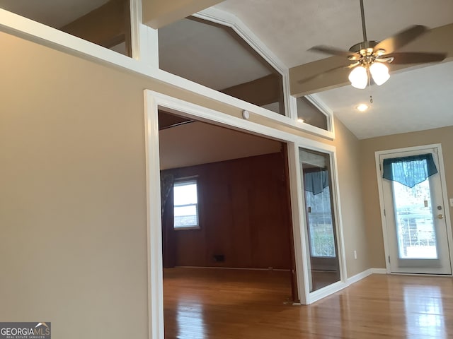 interior space with lofted ceiling with beams, plenty of natural light, and wood finished floors