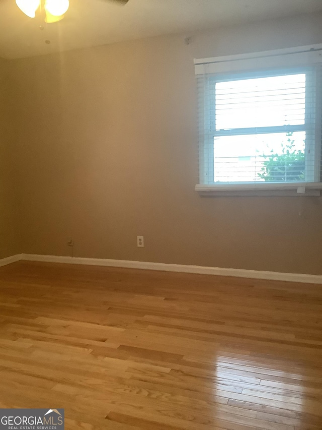 empty room with light wood finished floors and baseboards