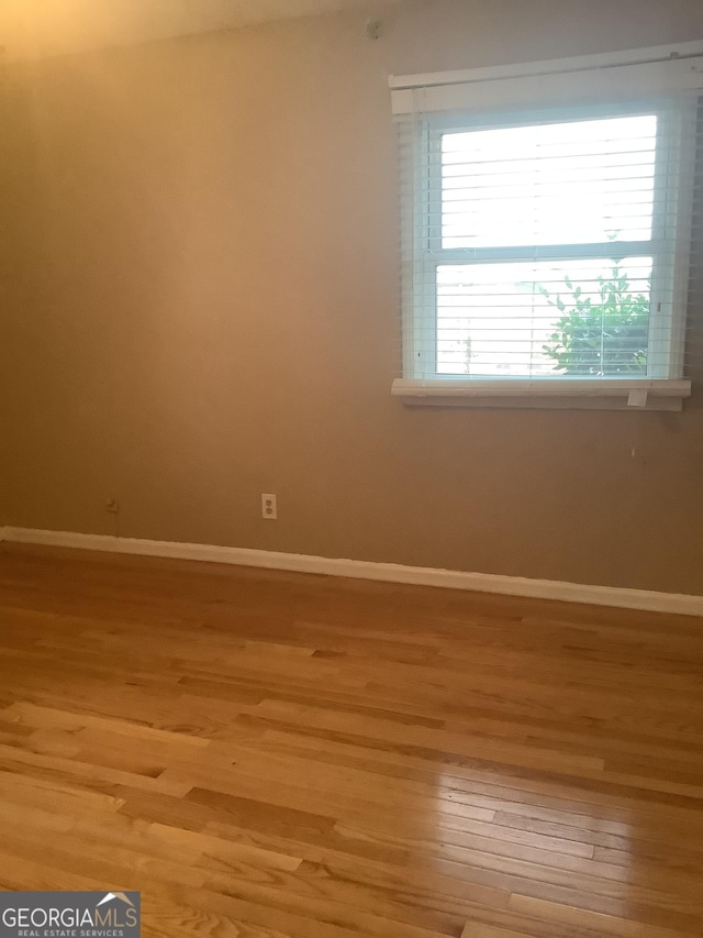 empty room with light wood-style floors and baseboards