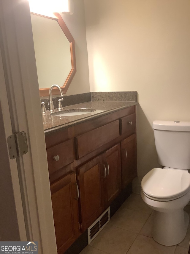 half bath with visible vents, toilet, vanity, and tile patterned flooring