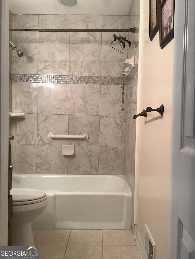 bathroom featuring tile patterned floors, visible vents, toilet, and washtub / shower combination