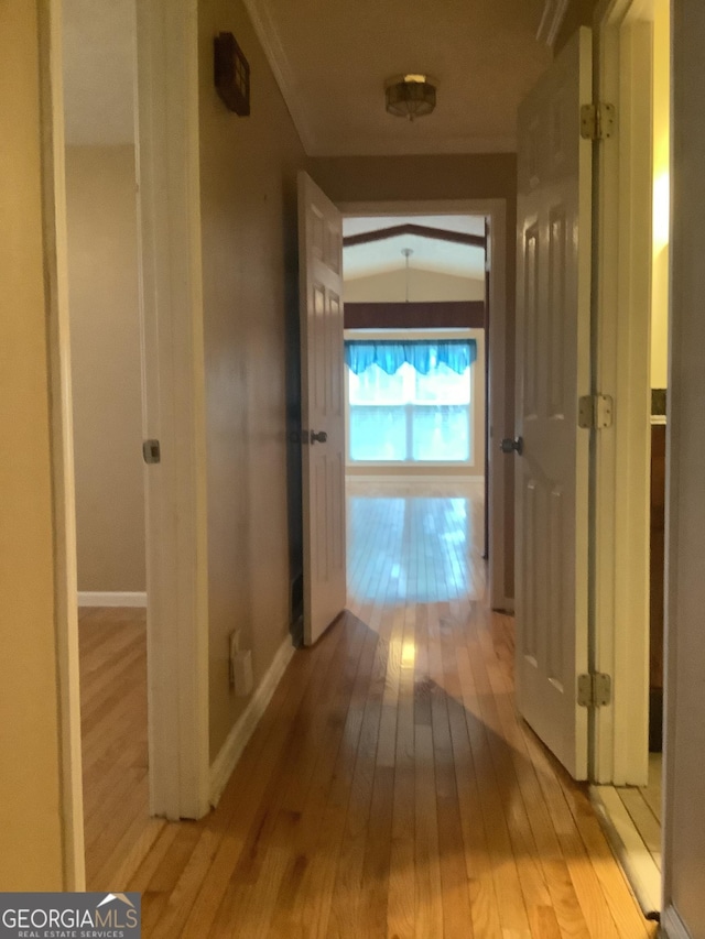 corridor featuring baseboards and light wood-style floors