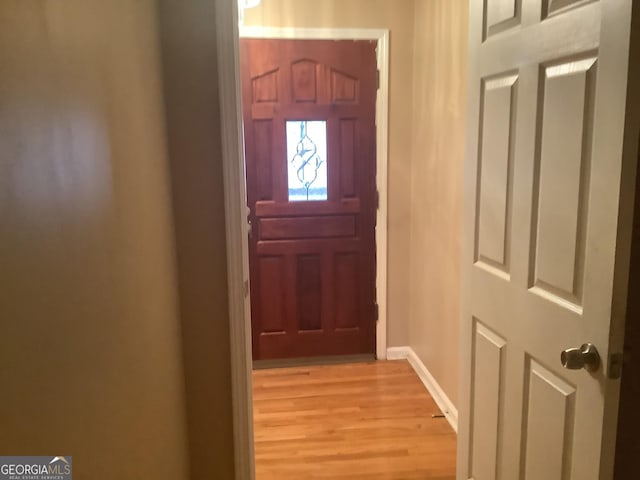 doorway to outside with light wood-type flooring and baseboards