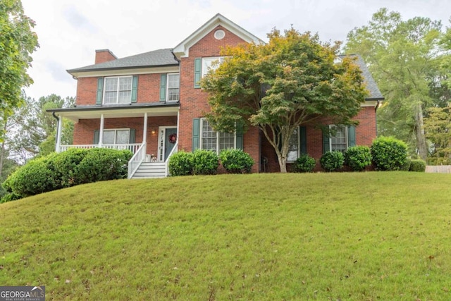 colonial home featuring a front yard and a porch