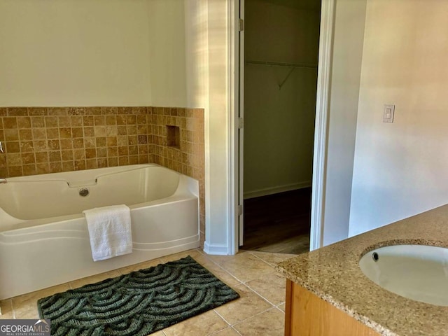 bathroom with a bath, vanity, and tile patterned floors