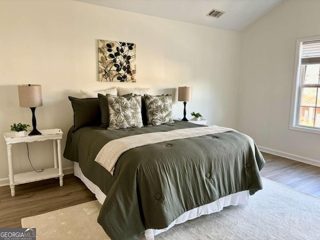 bedroom featuring vaulted ceiling and hardwood / wood-style flooring