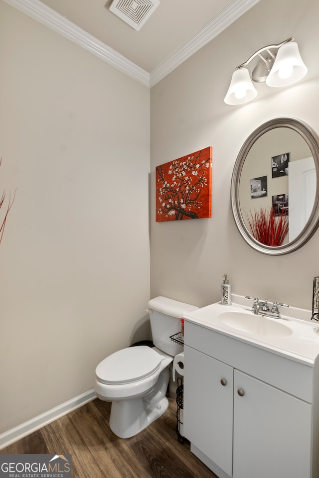 bathroom with ornamental molding, hardwood / wood-style flooring, vanity, and toilet