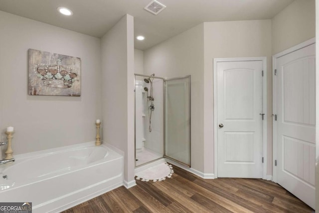 bathroom featuring plus walk in shower and hardwood / wood-style flooring