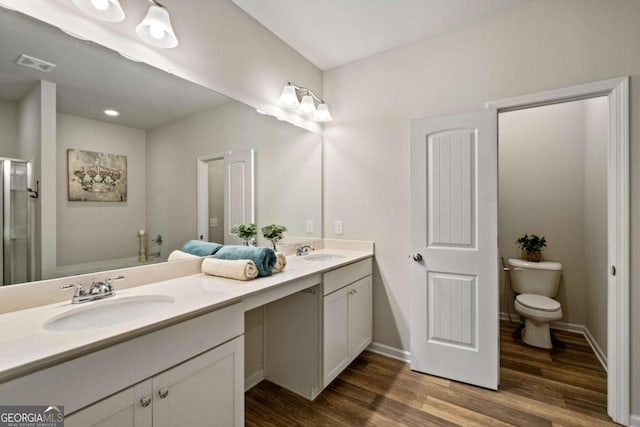 bathroom featuring wood-type flooring, vanity, and toilet