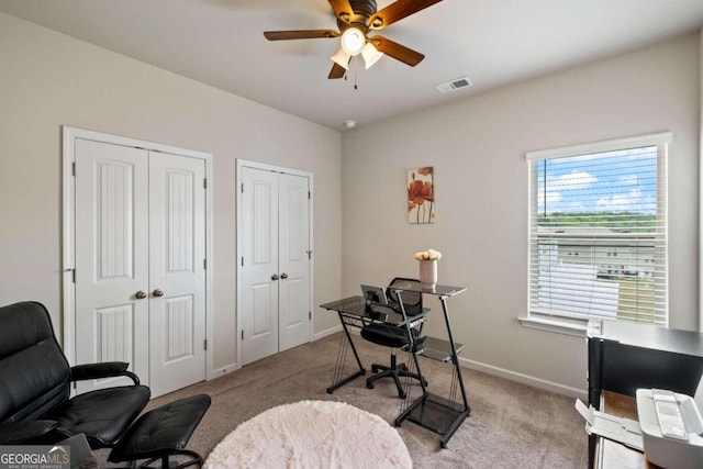 carpeted home office with ceiling fan