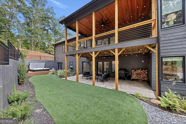 view of yard featuring ceiling fan, a jacuzzi, a patio, and an outdoor hangout area