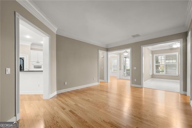 empty room featuring light hardwood / wood-style flooring, ceiling fan, and ornamental molding