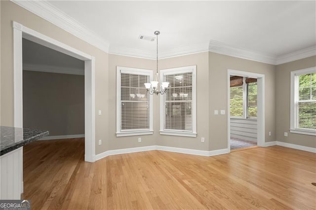 unfurnished dining area with an inviting chandelier, wood-type flooring, and crown molding