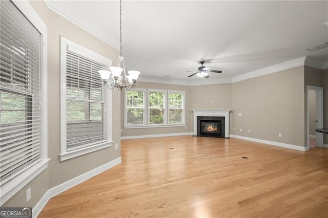 unfurnished living room with ceiling fan with notable chandelier, a fireplace, ornamental molding, and light hardwood / wood-style flooring