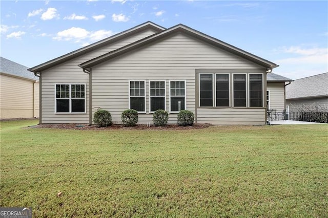 rear view of property featuring a lawn