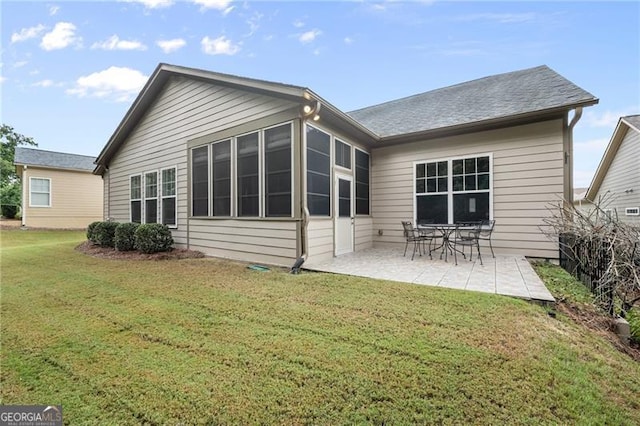 rear view of house featuring a lawn and a patio