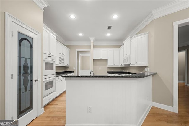 kitchen featuring white cabinetry, white appliances, kitchen peninsula, crown molding, and light hardwood / wood-style flooring