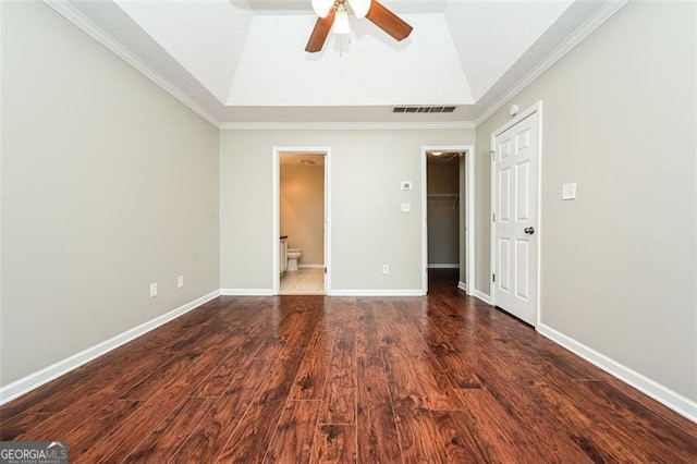 spare room featuring a raised ceiling, ornamental molding, dark hardwood / wood-style floors, and ceiling fan