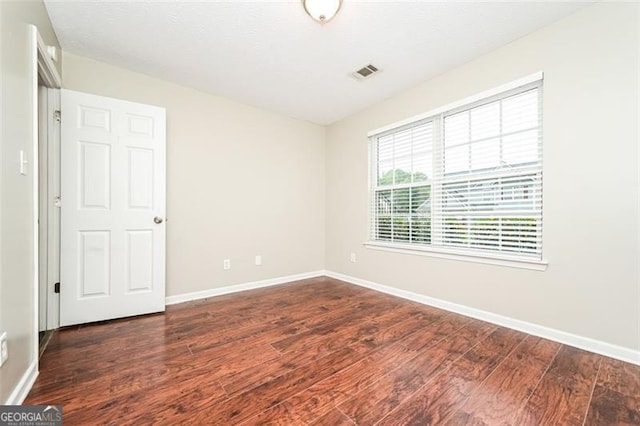 unfurnished room featuring dark wood-type flooring