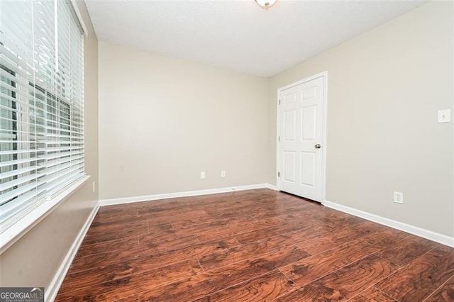 spare room with dark hardwood / wood-style flooring