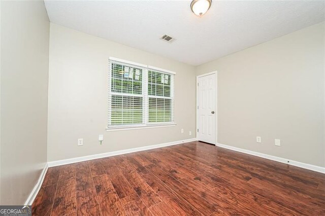 unfurnished room featuring dark wood-type flooring