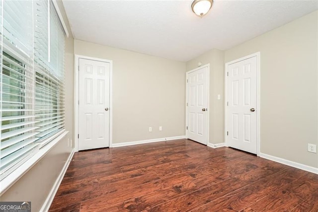 unfurnished bedroom with dark hardwood / wood-style floors