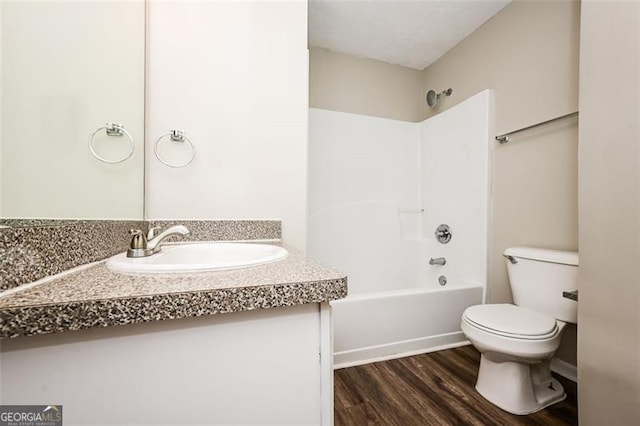 full bathroom with wood-type flooring, bathing tub / shower combination, vanity, and toilet