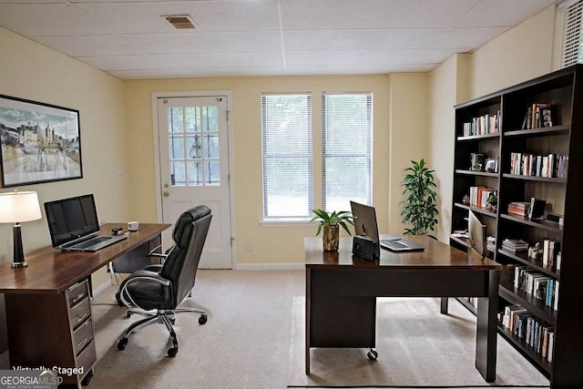 office space with a paneled ceiling and light colored carpet