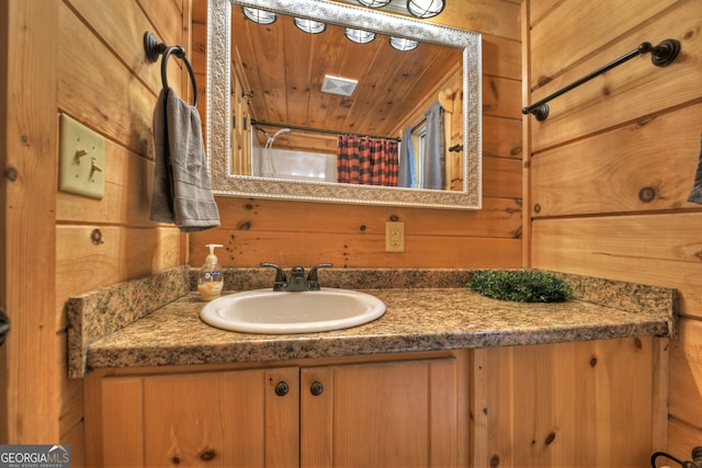 bathroom with a shower with curtain, vanity, wooden walls, and wood ceiling