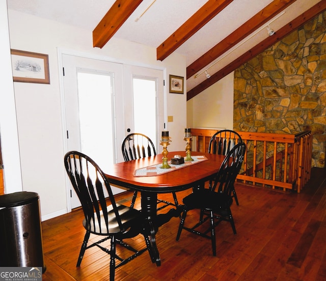 dining space featuring vaulted ceiling with beams and dark wood-type flooring