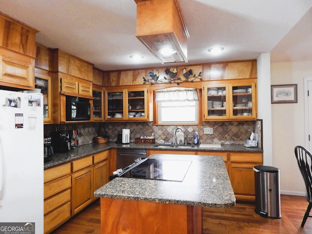 kitchen featuring white refrigerator, backsplash, dark hardwood / wood-style flooring, a center island, and sink