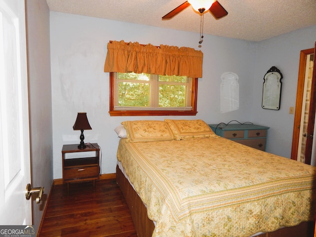 bedroom with a textured ceiling, dark hardwood / wood-style floors, and ceiling fan