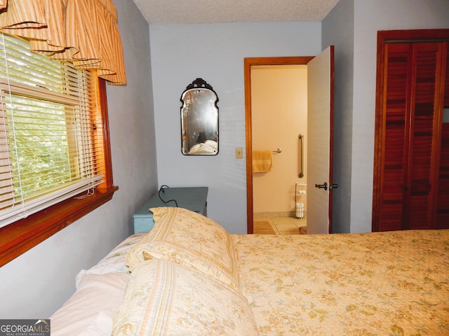 bedroom with a textured ceiling and a closet