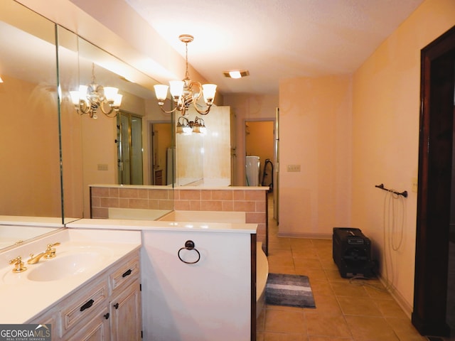 bathroom with backsplash, vanity, an inviting chandelier, and tile patterned floors